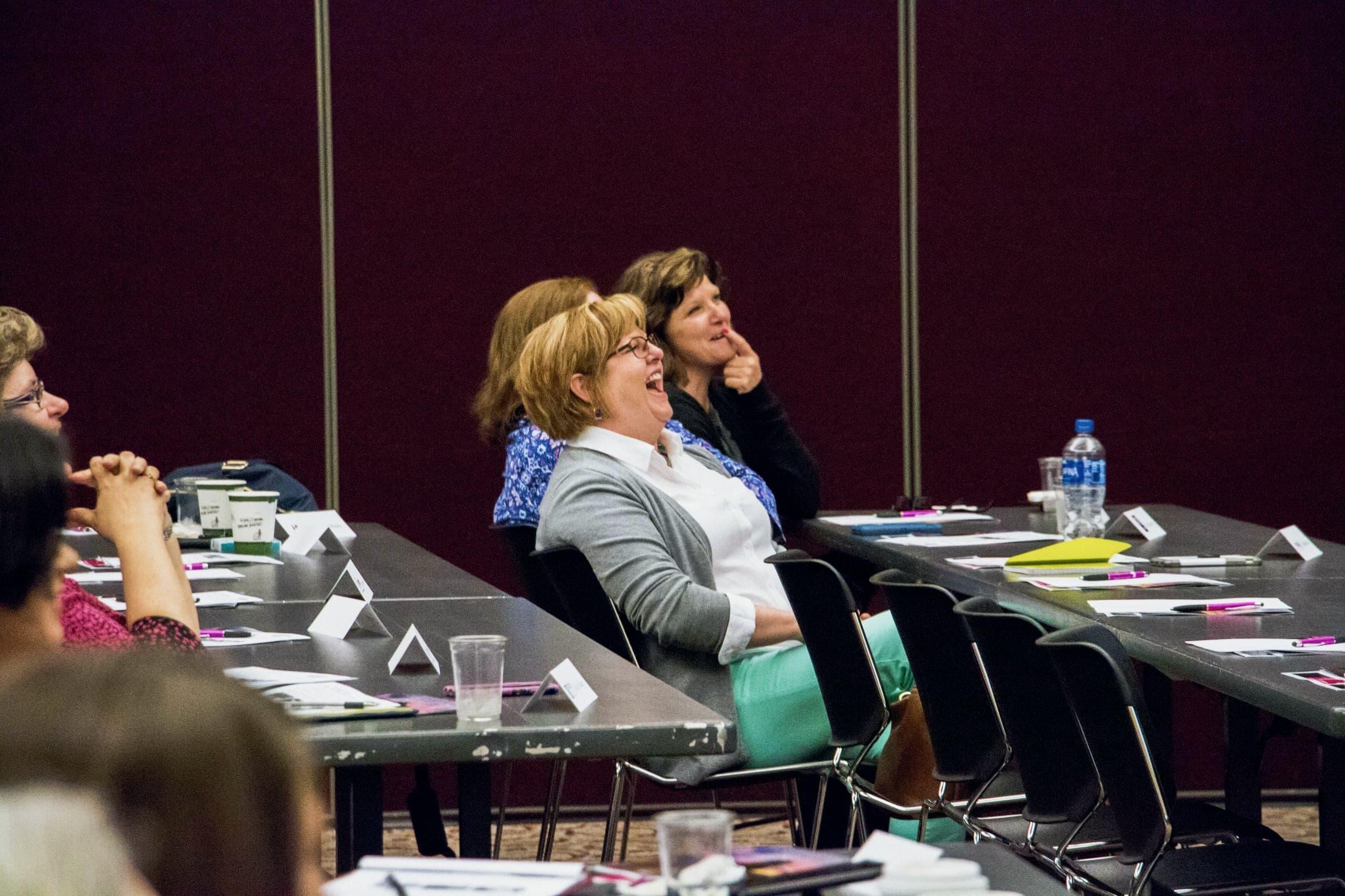 Audience members laughing at their tables during one of Kevin’s sessions